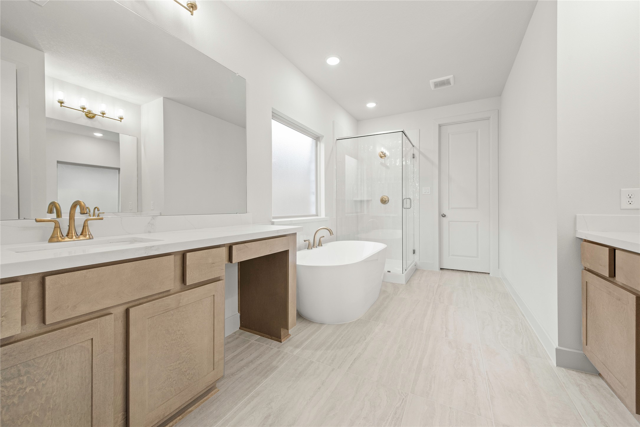 206 Sierra Stream Lane Conroe, TX 77304 - Photo 8 of 28 a spacious bathroom with a double vanity sink a mirror and a bathtub