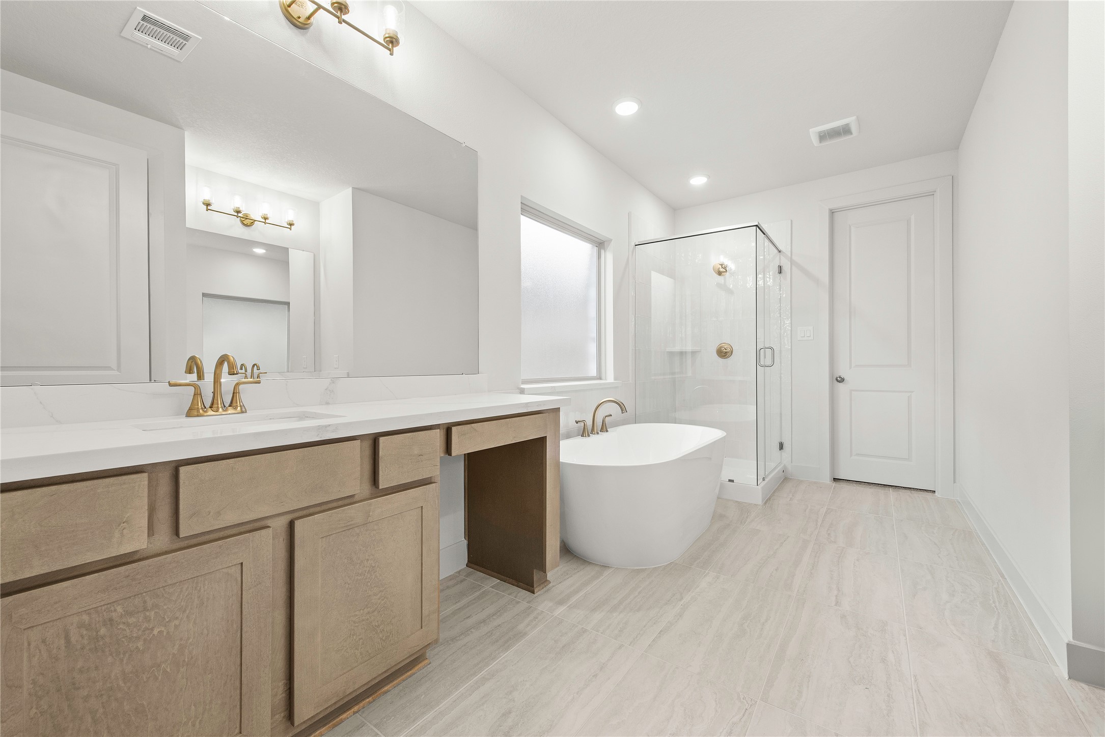 206 Sierra Stream Lane Conroe, TX 77304 - Photo 9 of 28 a spacious bathroom with a double vanity sink a mirror and a bathtub