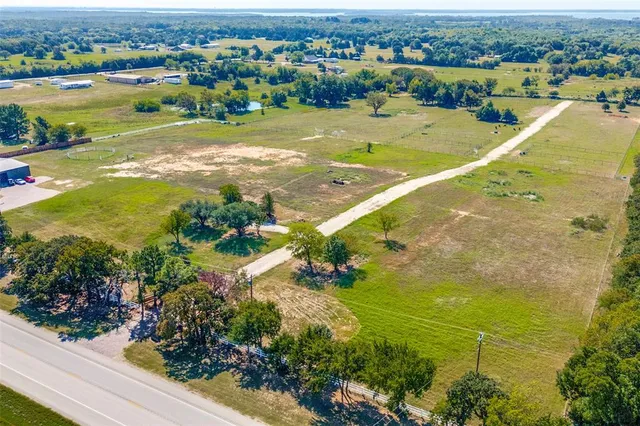 an aerial view of a houses with outdoor space and tennis court