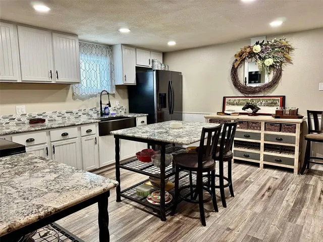 a kitchen with a stove a refrigerator and wooden floor