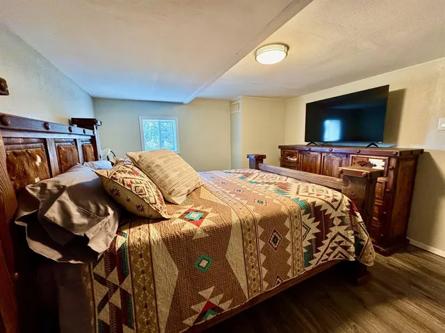 a bedroom with a bed and a flat screen tv