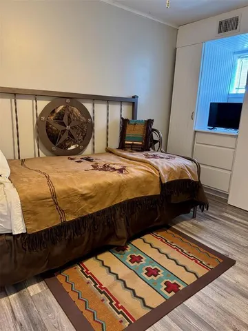 a bedroom with bed and wooden floor