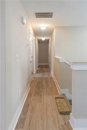 a view of a hallway with wooden floor and staircase