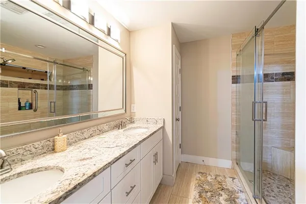 a bathroom with a granite countertop sink and a mirror
