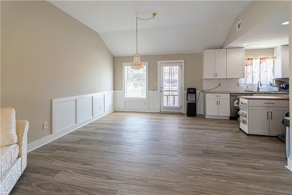 a large kitchen with cabinets wooden floor and stainless steel appliances
