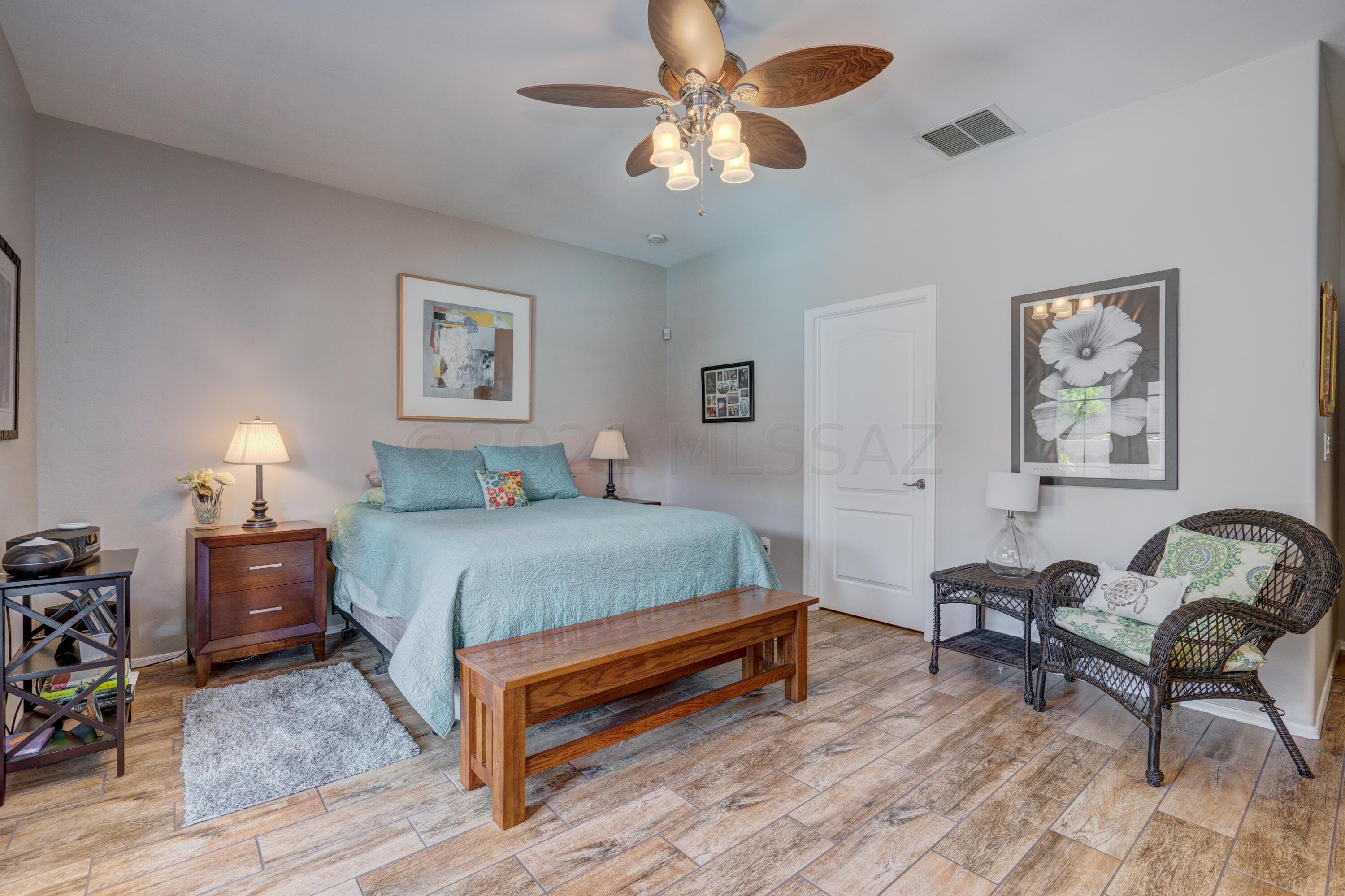 3639 East Northern Dancer Road Tucson, AZ 85739 - Photo 24 of 48 a bedroom with a bed a chair and a potted plant