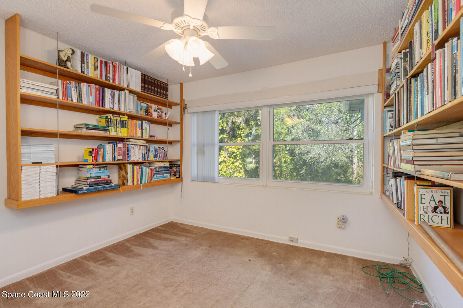216 Dubber Road Melbourne, FL 32901 - Photo 19 of 39 a view of an empty room with a window and a book shelf