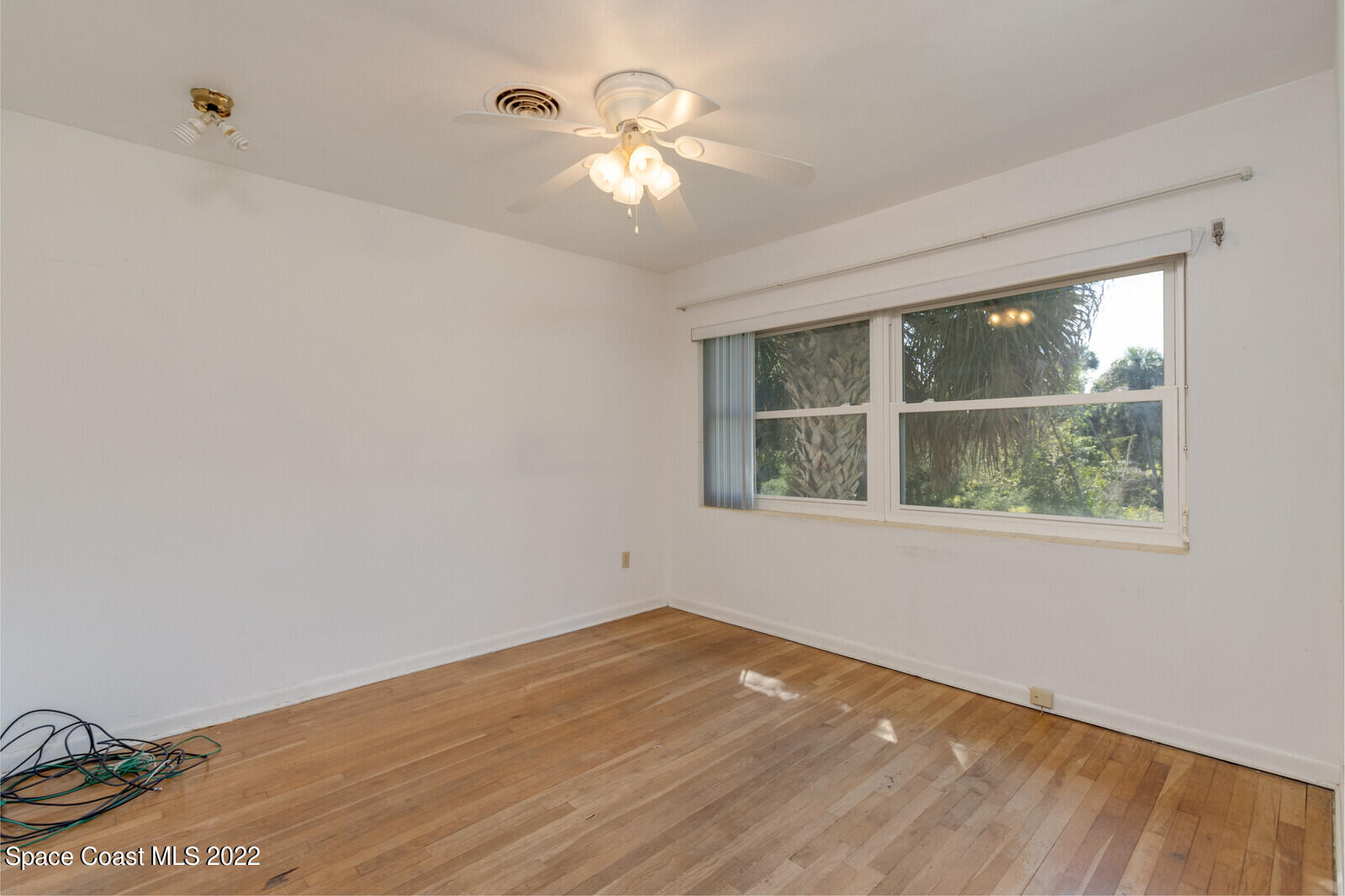 216 Dubber Road Melbourne, FL 32901 - Photo 25 of 39 a view of an empty room with wooden floor and a window