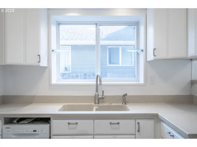 a kitchen with white cabinets a sink and appliances