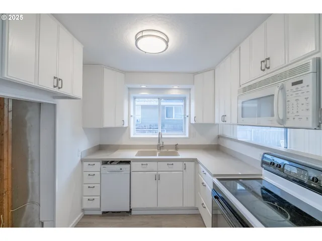 a kitchen with cabinets and steel appliances