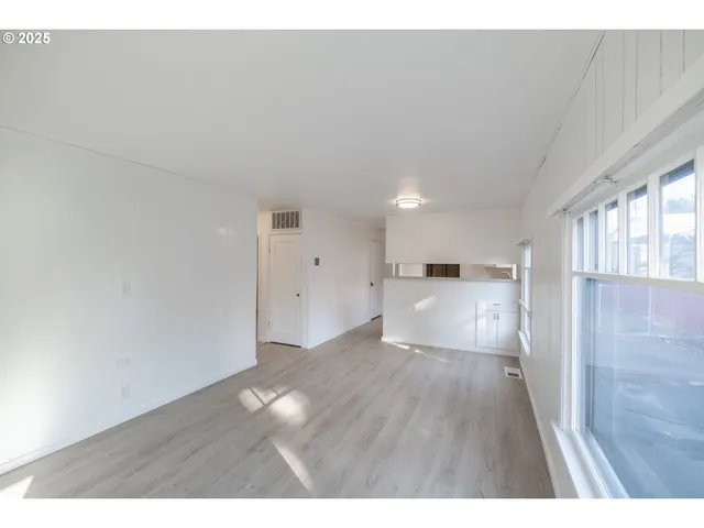 a view of empty room with wooden floor