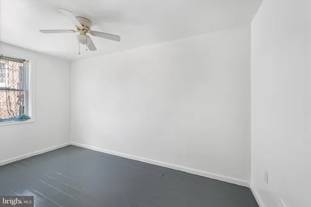 an empty room with a window and a ceiling fan