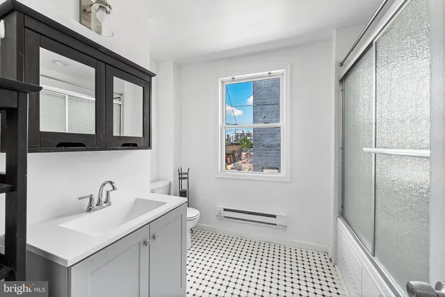 a bathroom with a sink a toilet and mirror