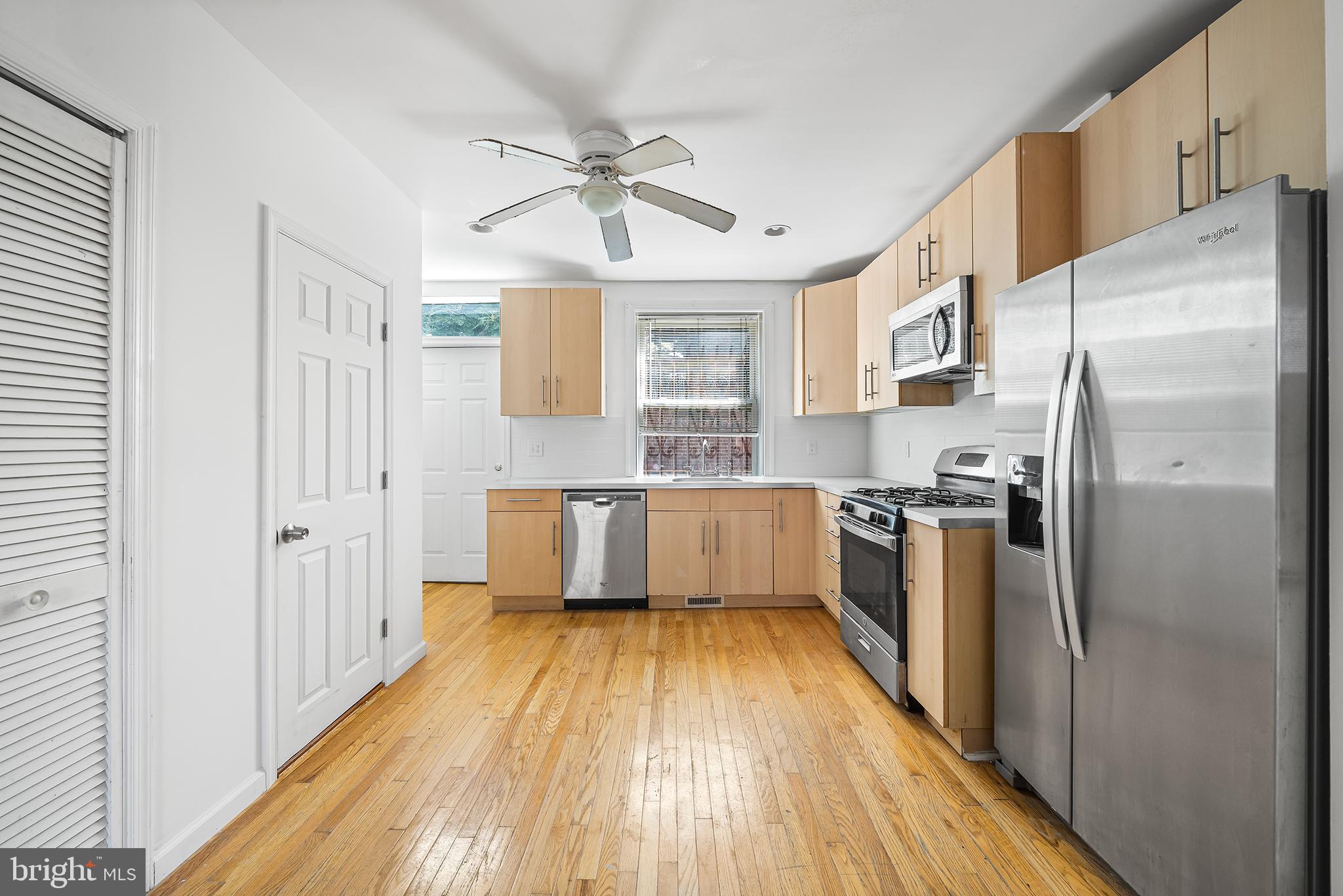 1615 North Philip Street Philadelphia, PA 19122 - Photo 3 of 22 a kitchen with a refrigerator a sink and dishwasher with wooden floor