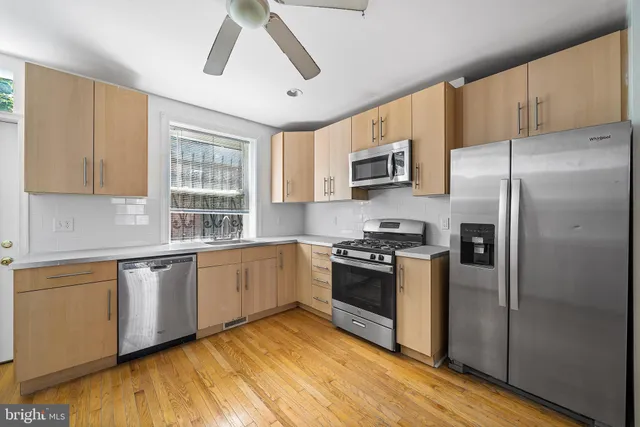 a kitchen with stainless steel appliances granite countertop a stove a sink dishwasher a refrigerator and a microwave oven