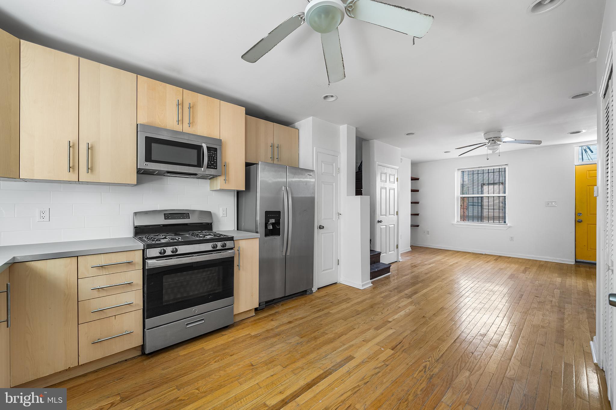 1615 North Philip Street Philadelphia, PA 19122 - Photo 5 of 22 a kitchen with stainless steel appliances granite countertop a stove top oven a refrigerator a sink and dishwasher with wooden floor