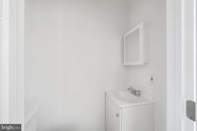 a bathroom with a sink a toilet and mirror
