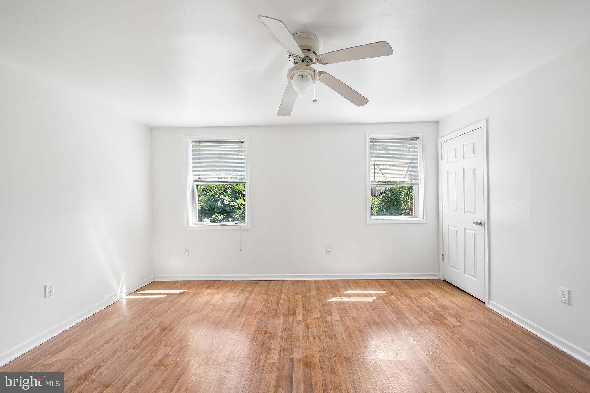 1615 North Philip Street Philadelphia, PA 19122 - Photo 9 of 22 an empty room with wooden floor ceiling fan and windows