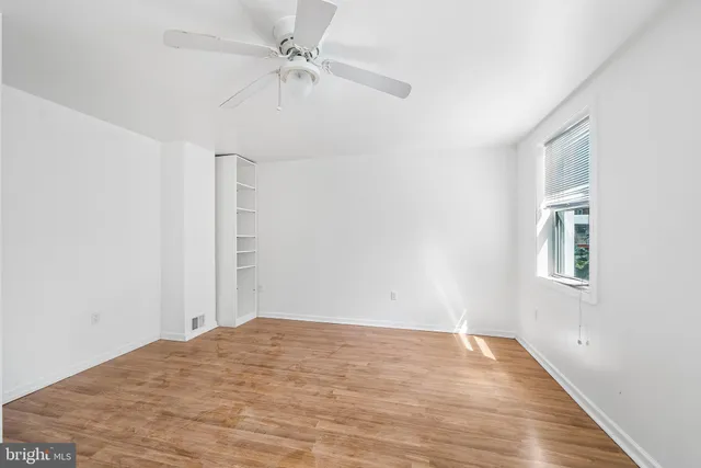 a view of empty room with wooden floor