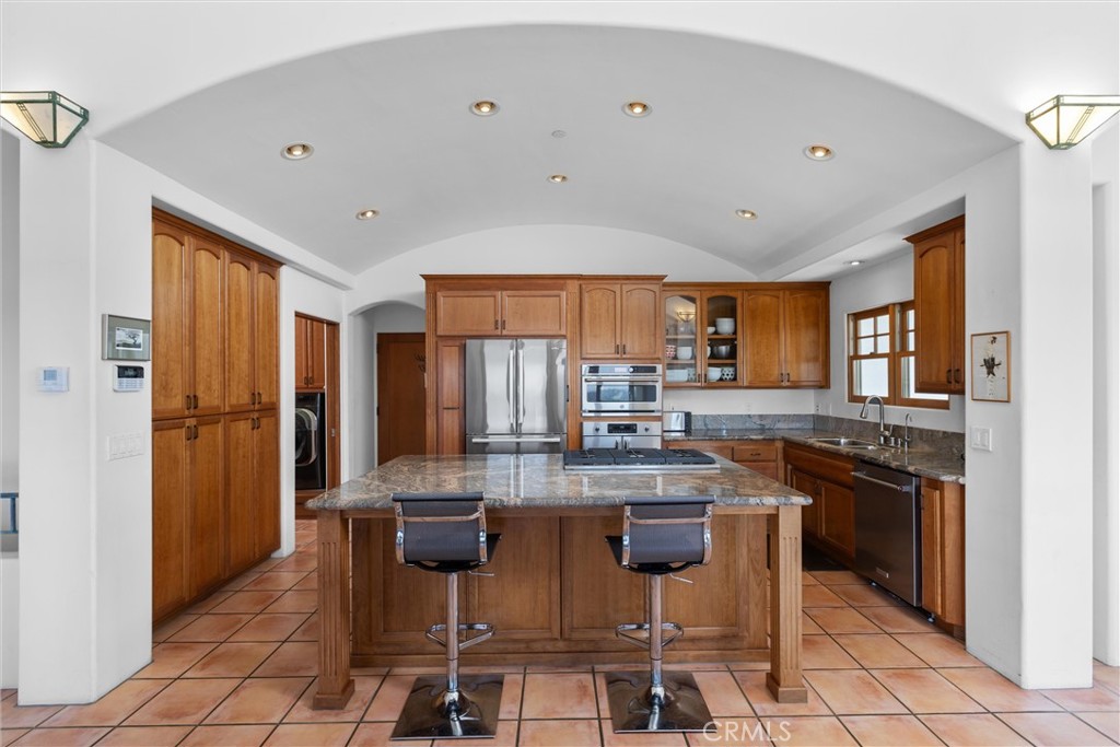 1790 Calle Laguna Arroyo Grande, CA 93420 - Photo 17 of 53 a kitchen with stainless steel appliances granite countertop a stove top oven a sink a dining table and chairs