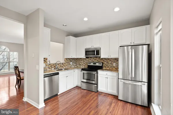 a kitchen with stainless steel appliances a refrigerator sink and microwave