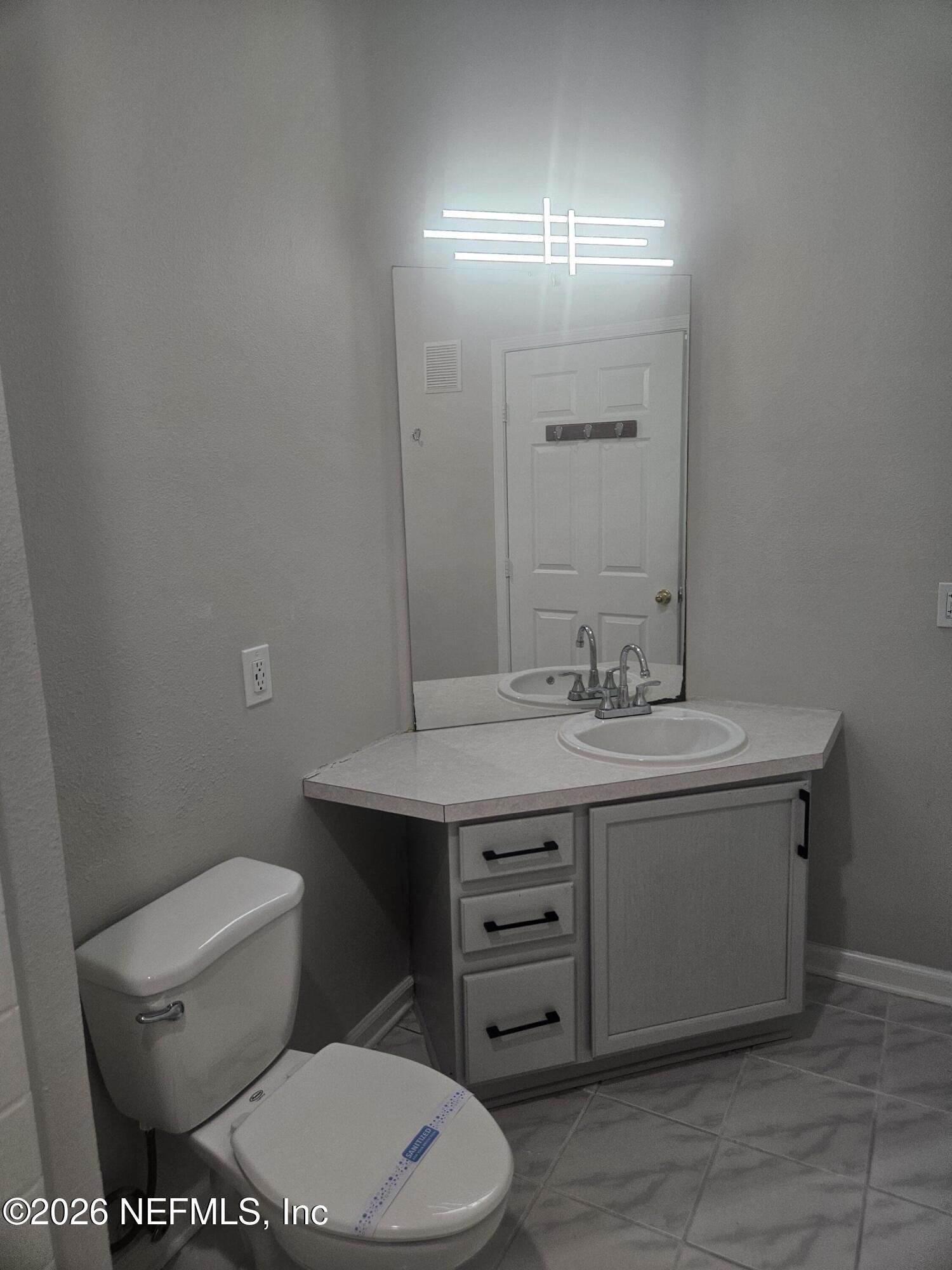 10550 Baymeadows Road, Unit 323 Jacksonville, FL 32256 - Photo 21 of 50 a bathroom with a toilet a sink and mirror