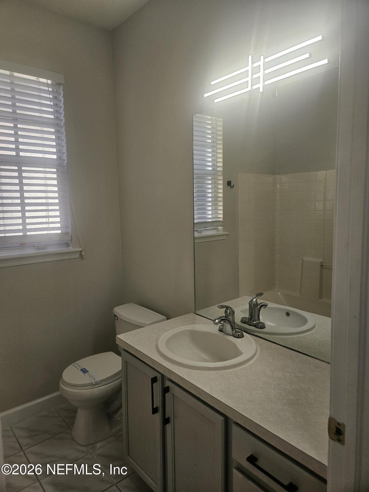 10550 Baymeadows Road, Unit 323 Jacksonville, FL 32256 - Photo 31 of 50 a bathroom with a sink a toilet and a mirror