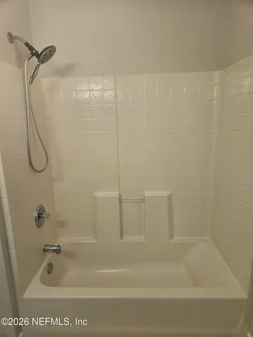a bathroom with a bath tub with a shower