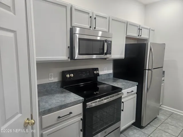 a kitchen with stainless steel appliances granite countertop a refrigerator stove and microwave