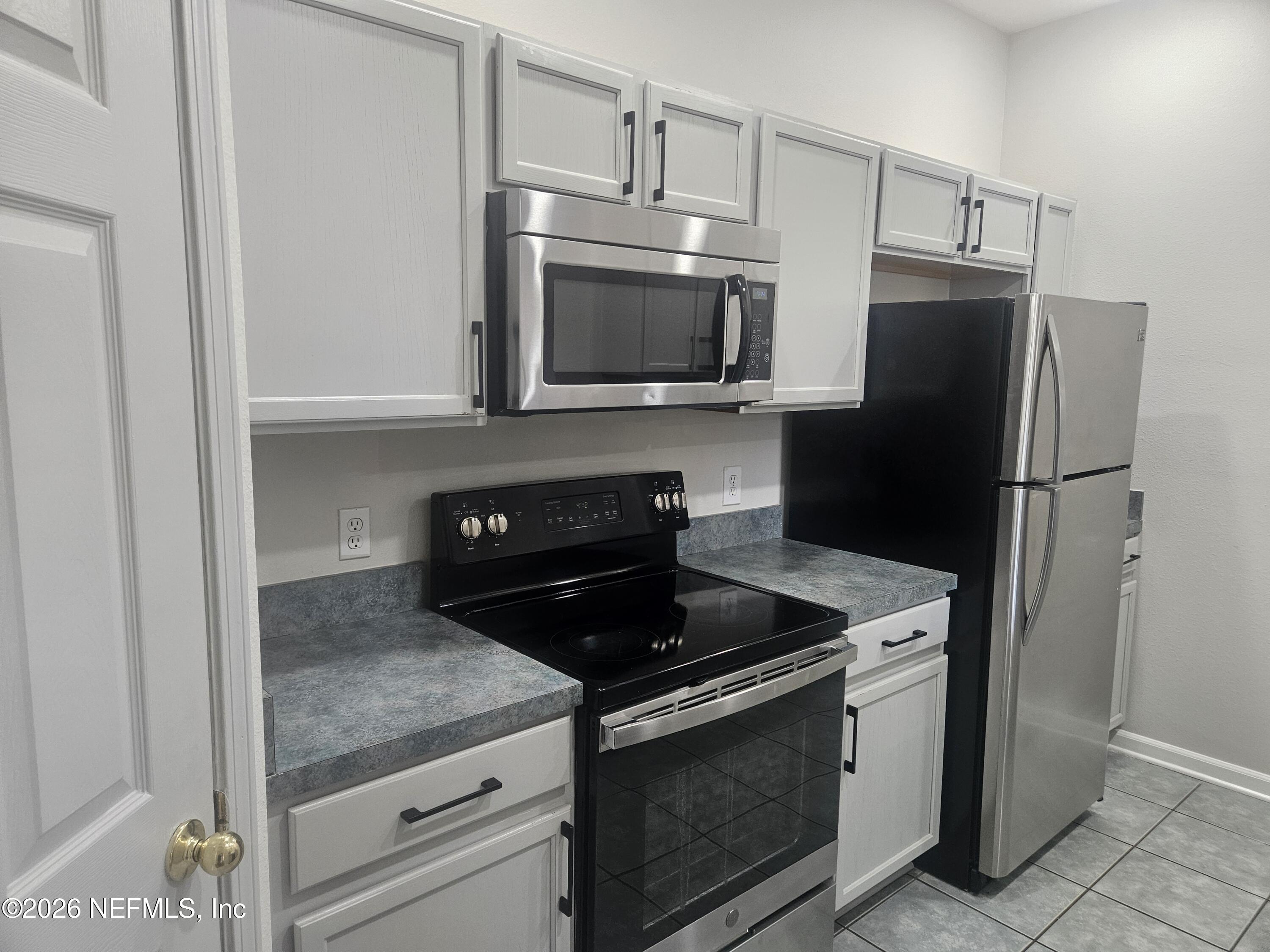 10550 Baymeadows Road, Unit 323 Jacksonville, FL 32256 - Photo 6 of 50 a kitchen with stainless steel appliances granite countertop a refrigerator stove and microwave
