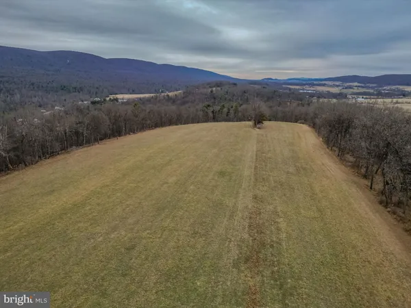 a view of a dry yard with mountains in the background