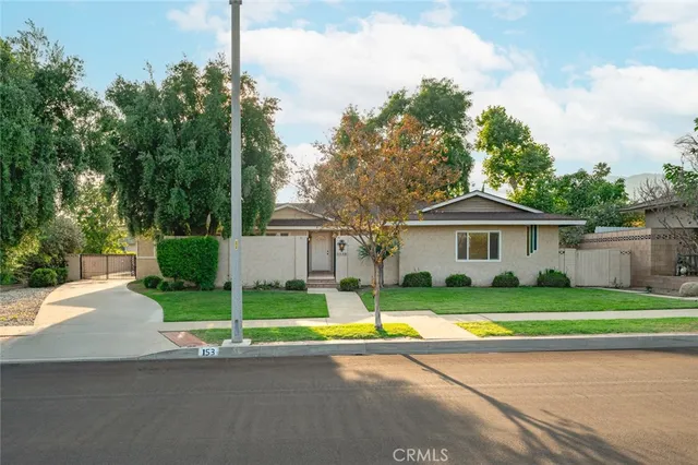 a front view of a house with a yard and trees