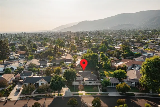 an aerial view of house with yard and mountain view in back