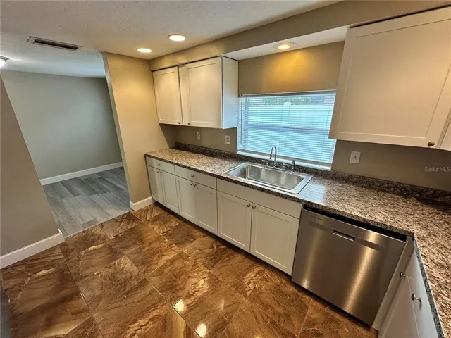 a kitchen with stainless steel appliances granite countertop a sink stove and cabinets