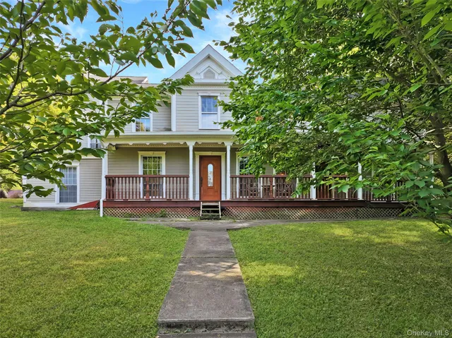a front view of a house with a yard and trees