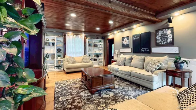 a living room with furniture a rug and potted plants