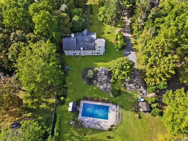 a view of a house with a big yard and large trees