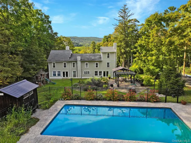 a backyard of a house with table and chairs under an umbrella