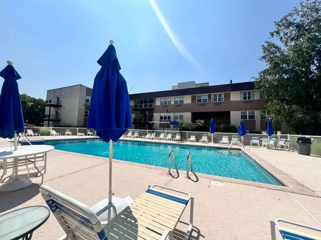 a kitchen with granite countertop a table chairs a sink dishwasher refrigerator and cabinets