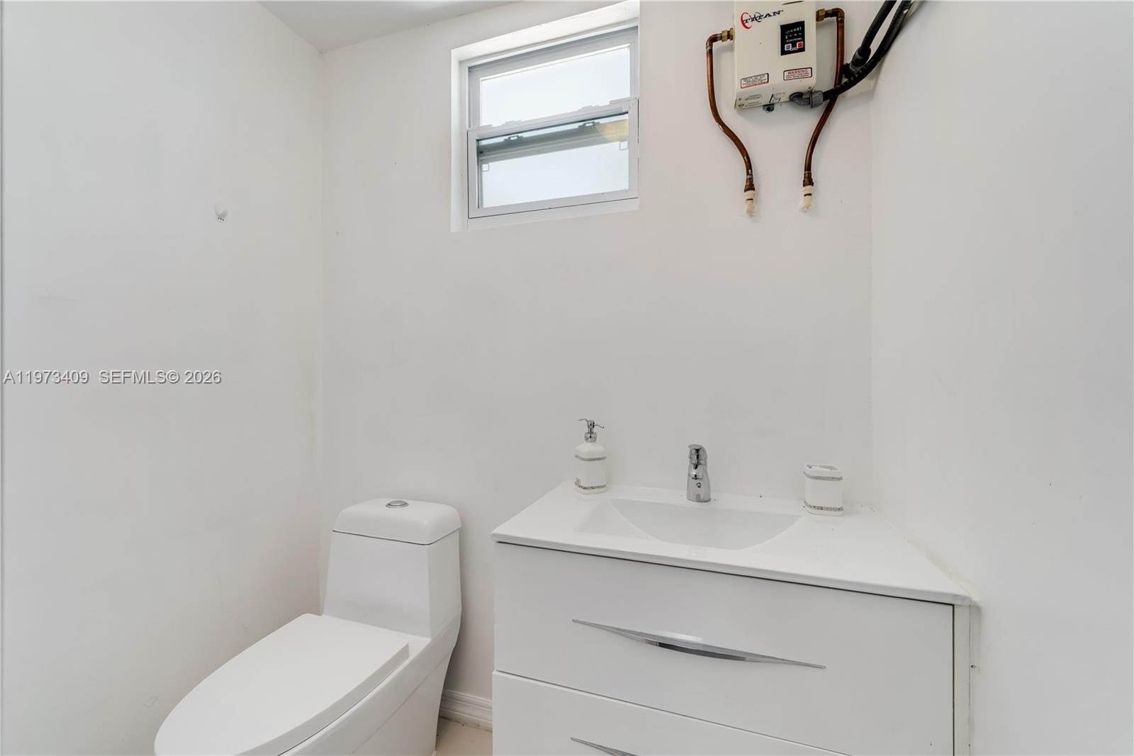 13050 Southwest 26th Street Miami, FL 33175 - Photo 36 of 43 a bathroom with a toilet a sink and mirror