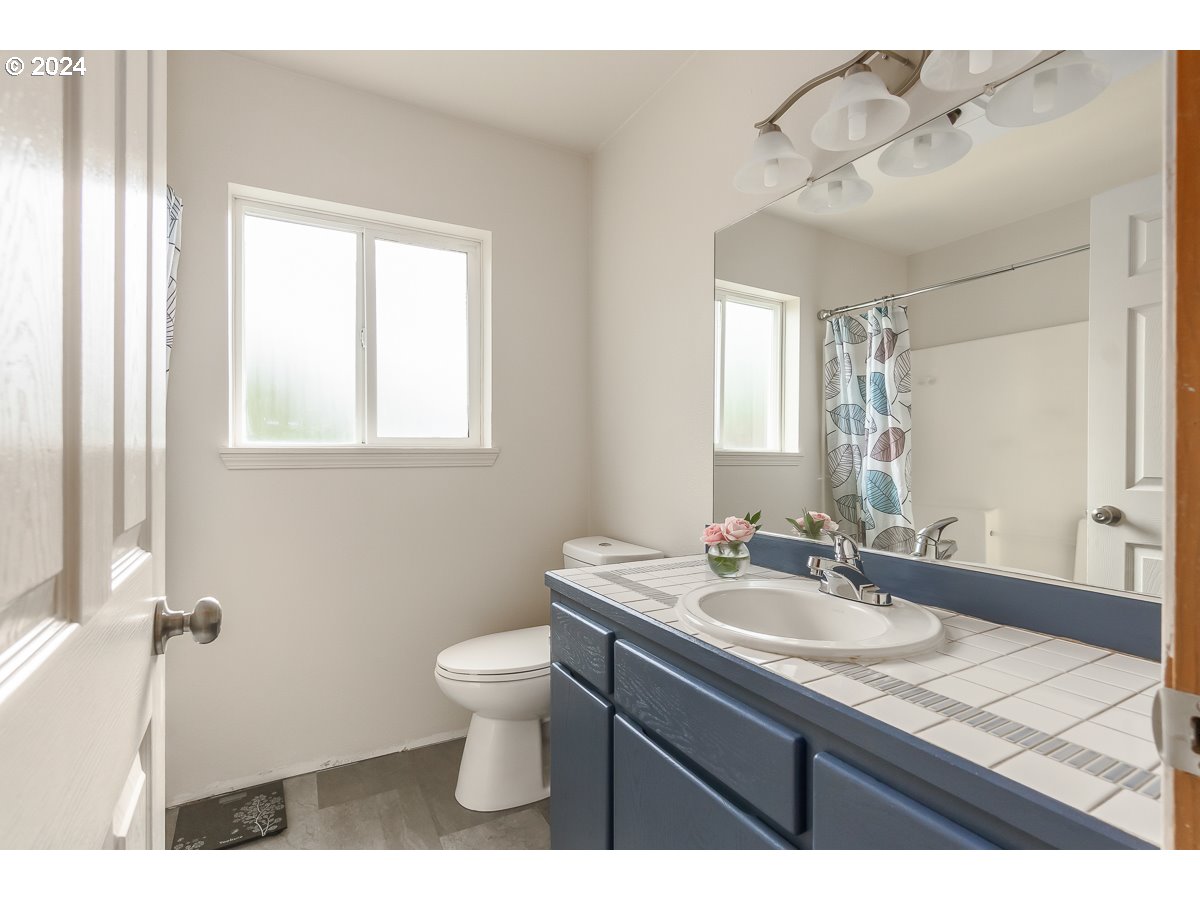 7822 Southwest 171st Place Beaverton, OR 97007 - Photo 10 of 20 a bathroom with a sink vanity granite toilet and a mirror
