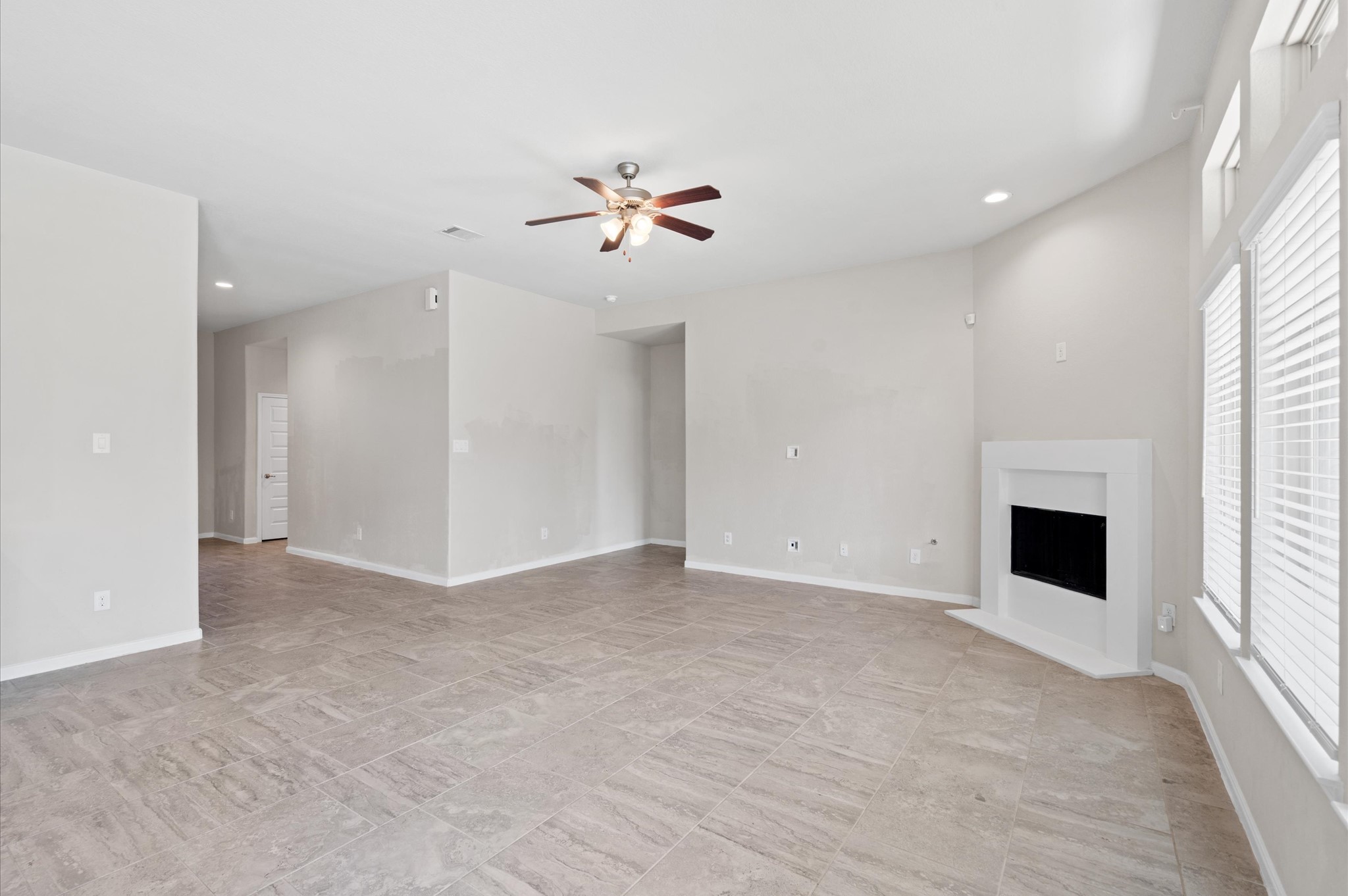 410 Richfish Run Drive Rosenberg, TX 77469 - Photo 8 of 30 Spacious and sunlit great room featuring a cozy fireplace and an elegant ceiling fan.
