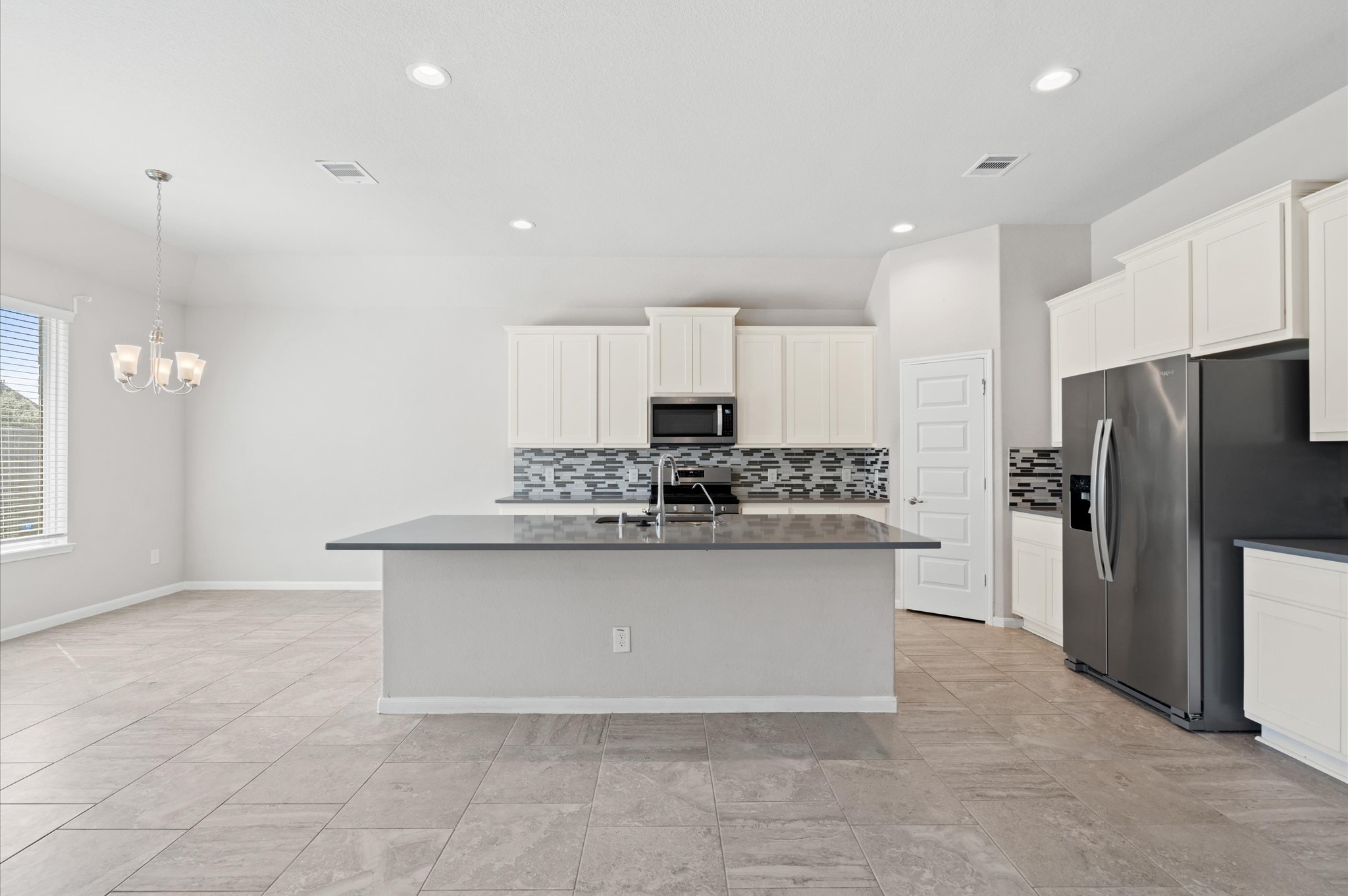 410 Richfish Run Drive Rosenberg, TX 77469 - Photo 9 of 30 Sleek kitchen and dining area boasting granite countertops, stainless steel appliances, and a spacious pantry.