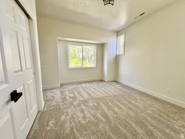 812 East Bates Cyn Road Tooele, UT 84074 - Photo 70 of 144 Bright room featuring two windows, neutral-toned carpet, and white trim