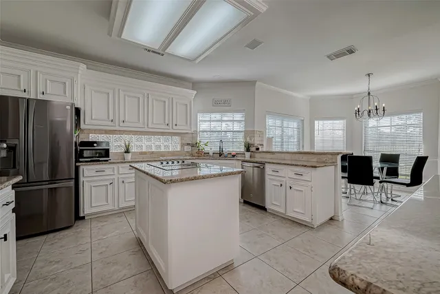 a large white bathroom with a granite countertop sink a toilet a mirror and bathtub