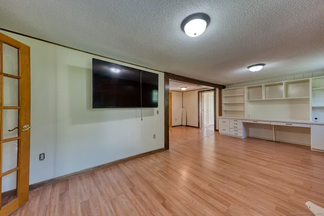 a view of a livingroom with wooden floor and a ceiling fan