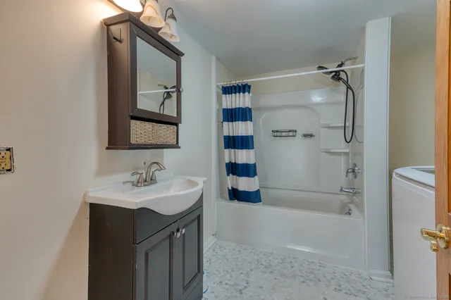 a bathroom with a sink a toilet and shower