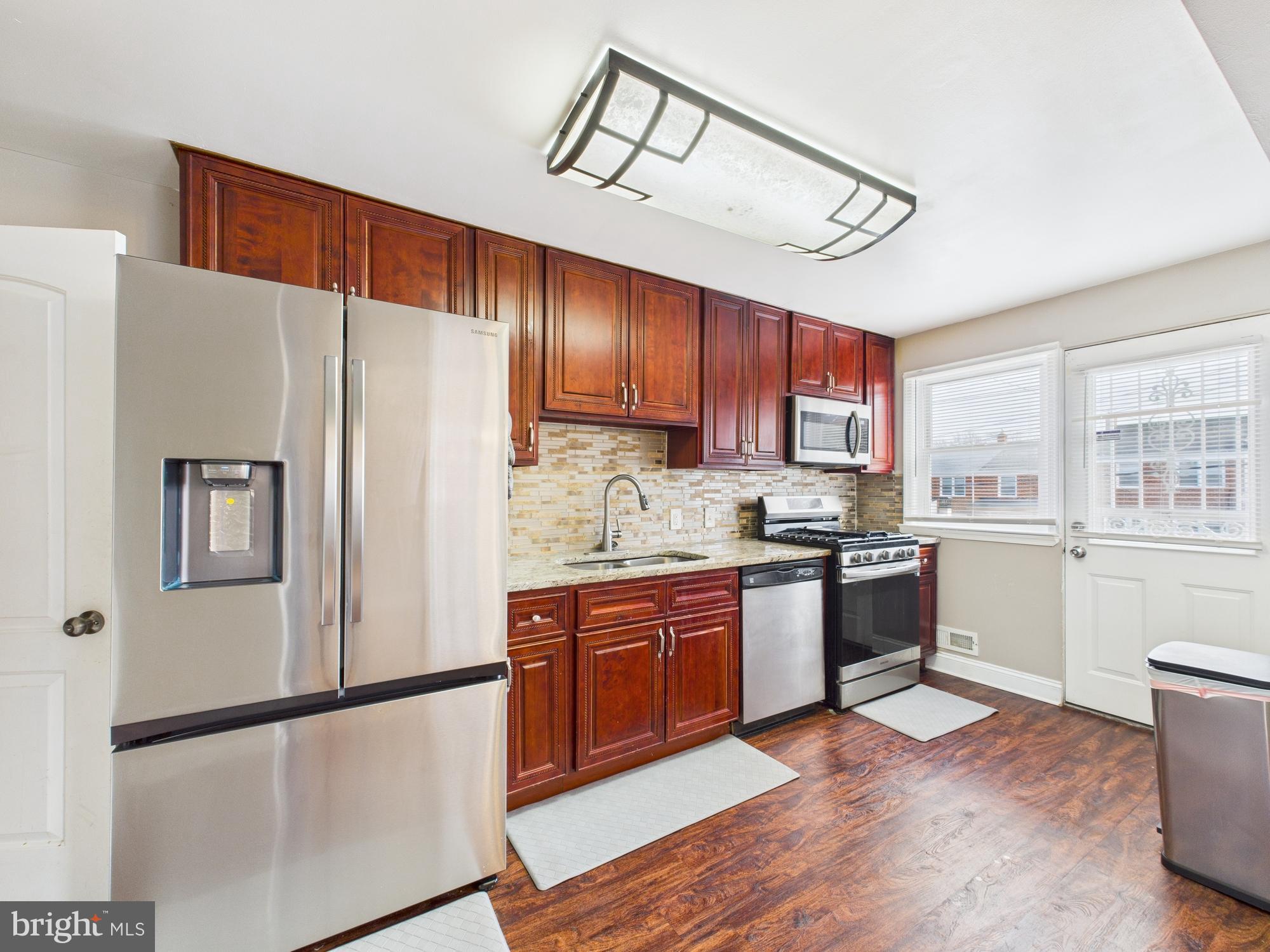 1551 Langford Road Baltimore, MD 21207 - Photo 12 of 52 a kitchen with granite countertop a refrigerator stove top oven and sink
