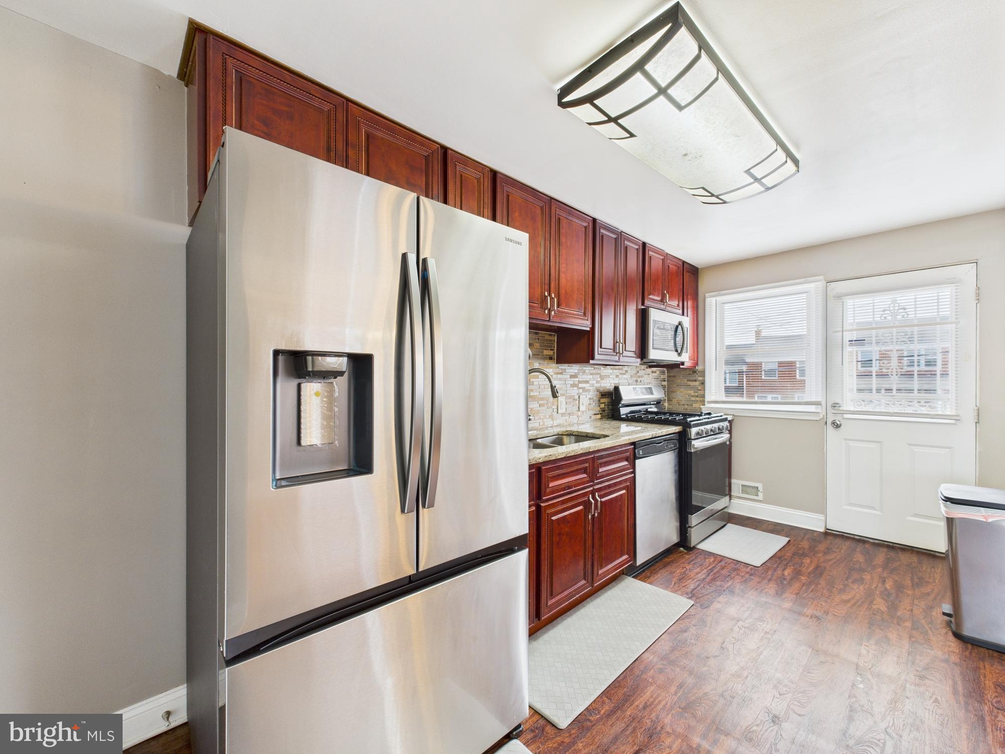 1551 Langford Road Baltimore, MD 21207 - Photo 13 of 52 a kitchen with stainless steel appliances a refrigerator and a stove top oven
