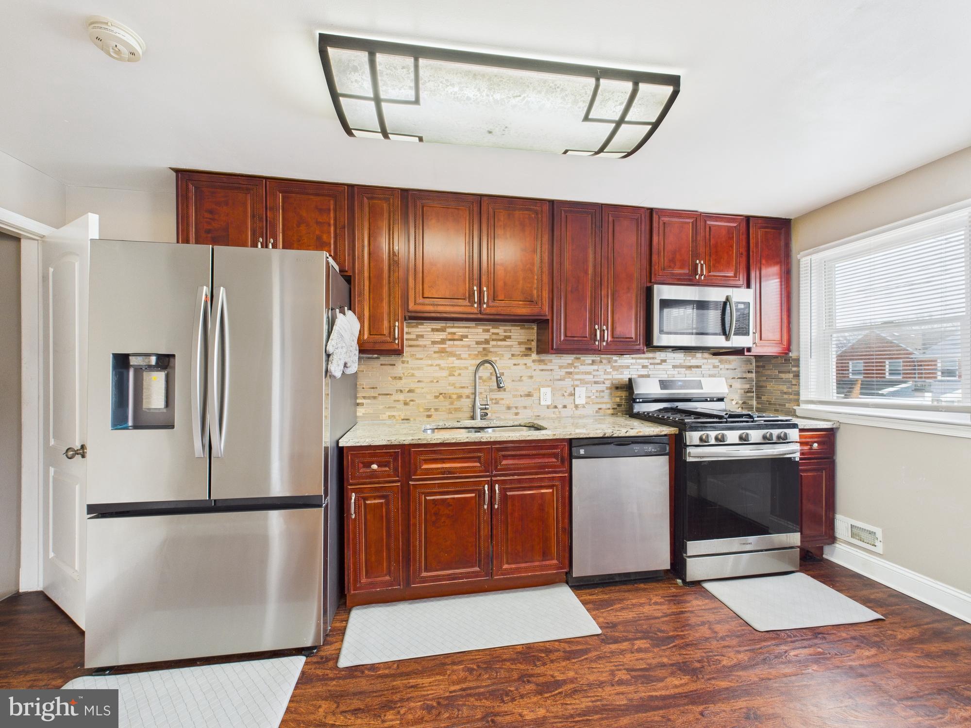1551 Langford Road Baltimore, MD 21207 - Photo 14 of 52 a kitchen with stainless steel appliances granite countertop a refrigerator sink and cabinets